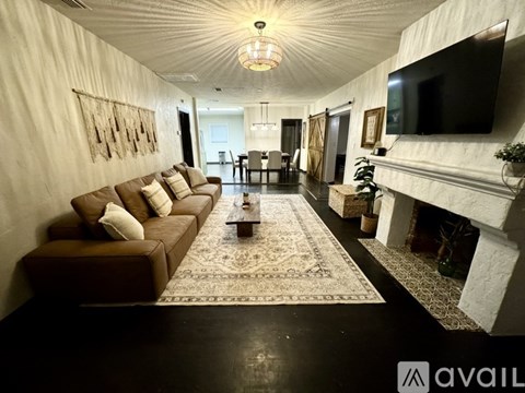 A living room with a brown couch and a fireplace.