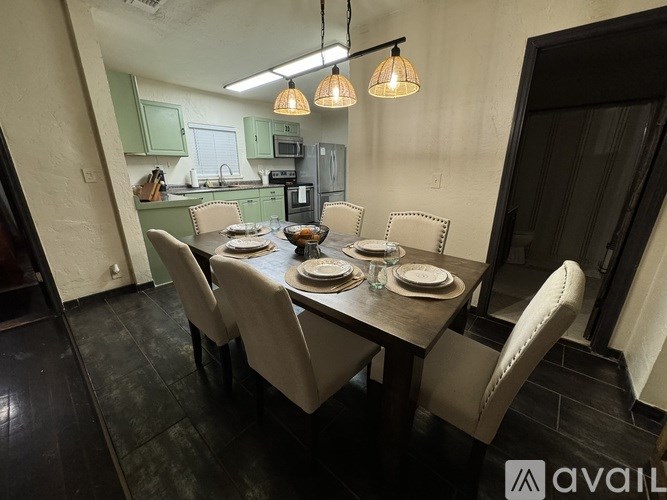 A dining room with a table set for six people.