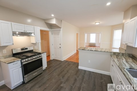 A kitchen with white cabinets and a black stove top oven.