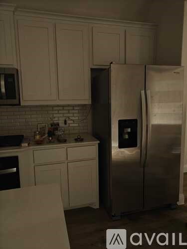 A kitchen with a refrigerator and cabinets.