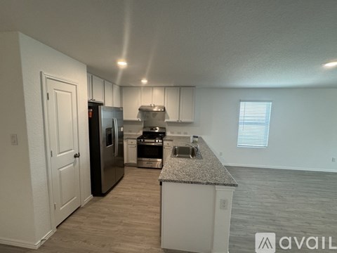 A kitchen with a granite countertop and stainless steel appliances.