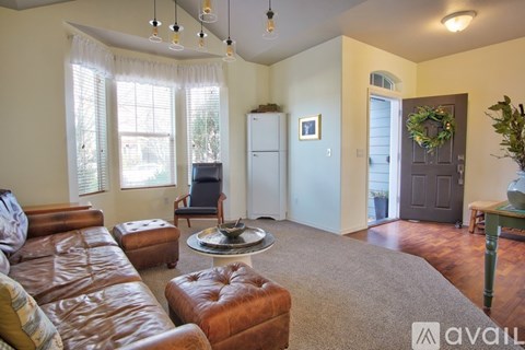 A living room with a brown leather couch and a glass coffee table.