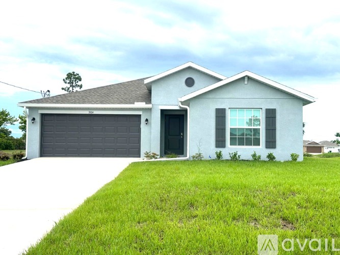 A two-story house with a garage and a driveway.