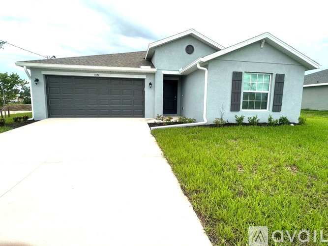 A house with a grey garage door and a white driveway.
