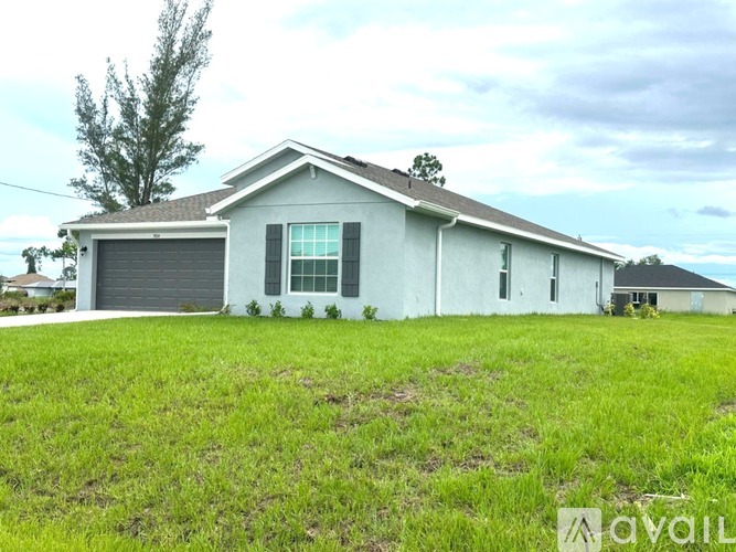 A house with a grey roof and a white wall is available for rent.