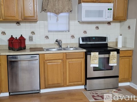 A kitchen with wooden cabinets and a stove top oven.