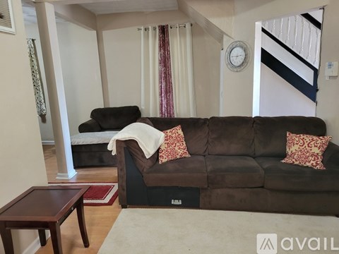 A living room with a brown couch and a small table.