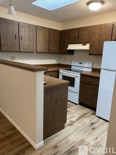 A kitchen with wooden cabinets and a white refrigerator.