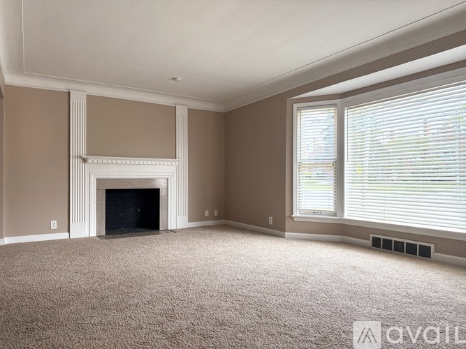 A living room with a fireplace and carpeted floor.