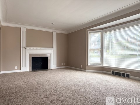 A living room with a fireplace and carpeted floor.