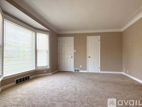 A room with two doors and a window with blinds.