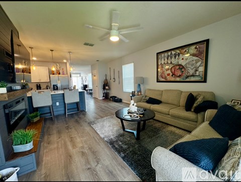 A living room with a couch, coffee table, and a painting on the wall.