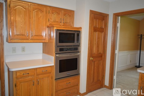 A kitchen with wooden cabinets and a white countertop.