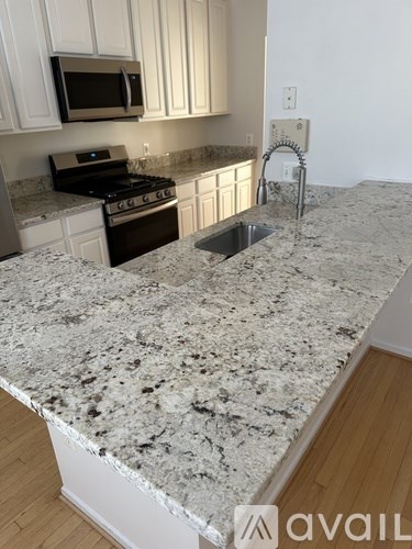 A kitchen with granite countertops and stainless steel appliances.