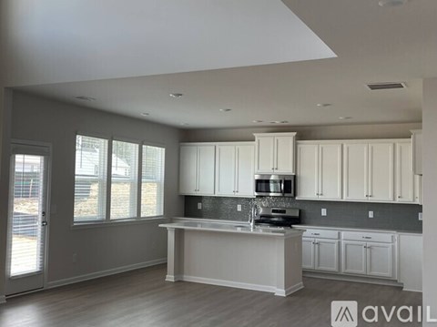 A kitchen with white cabinets and a central island.