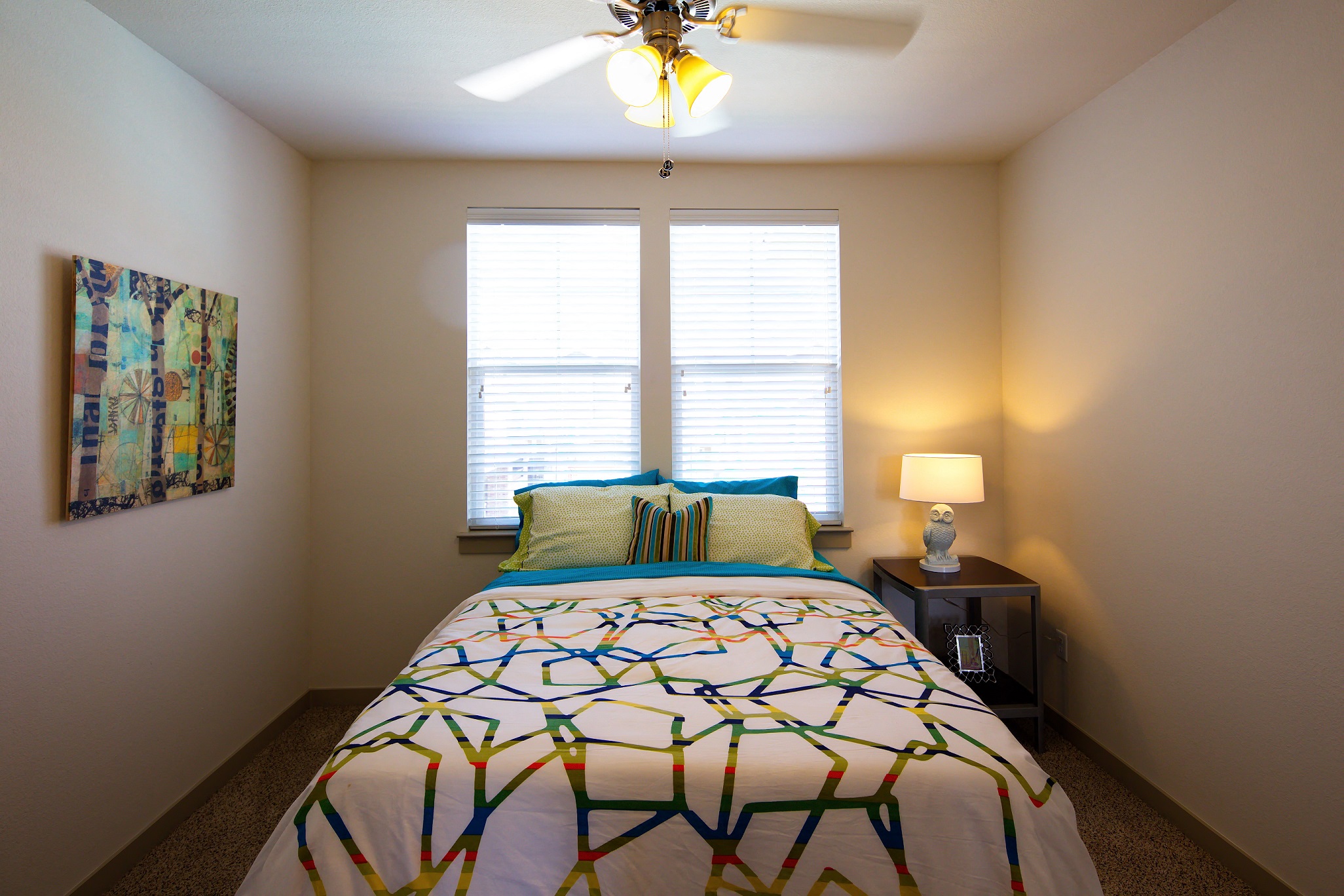 a bedroom with a bed and a ceiling fan