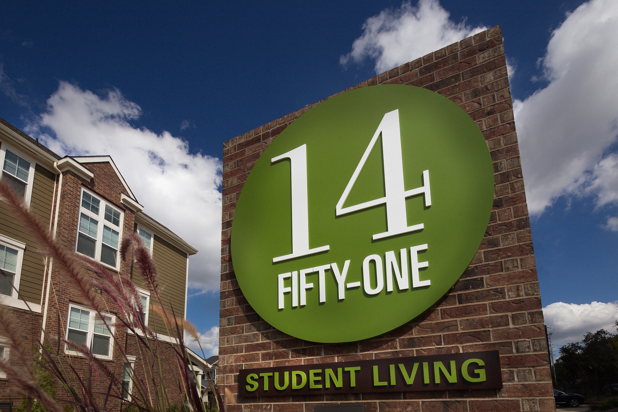 a sign on the side of a brick building that reads 14 student living at one