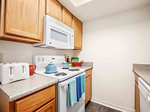 a kitchen with a white stove and microwave and wooden cabinets