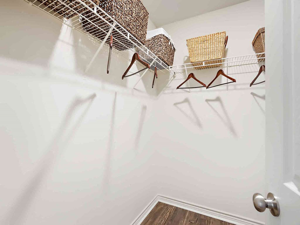 a walk in closet with chairs and a rack on the wall