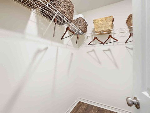 a walk in closet with chairs and a rack on the wall