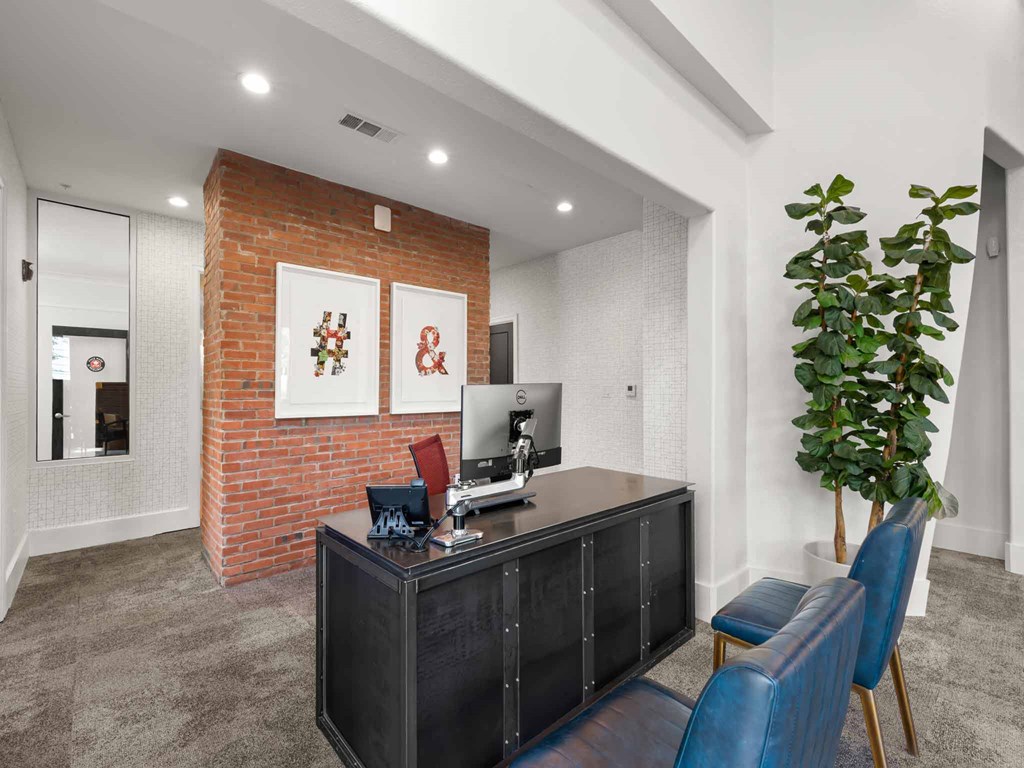 a office with blue chairs and a desk with a computer