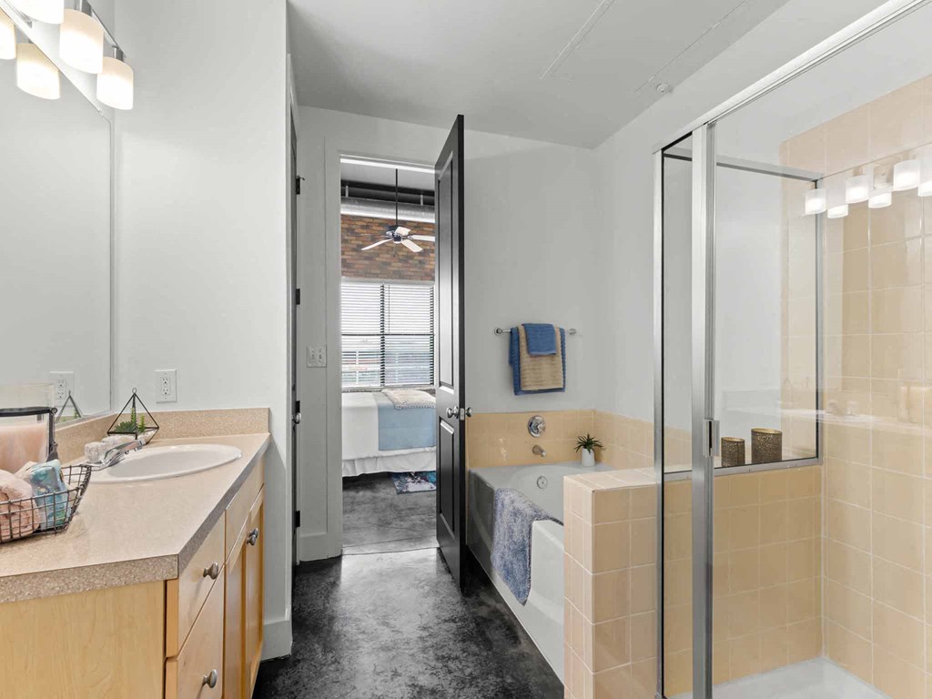 a bathroom with a tub and a shower and a sink