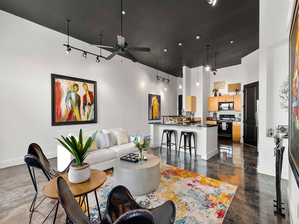 a living room with a couch and a table in front of a kitchen