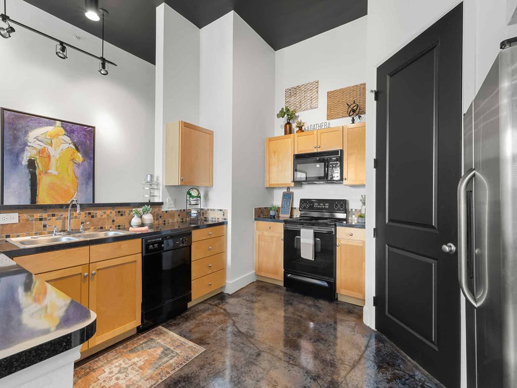 a kitchen with black appliances and a black door