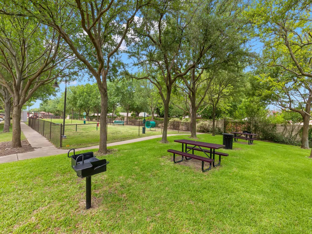 a park with a picnic table and a grill