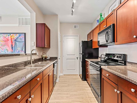 a kitchen with granite counter tops and black appliances