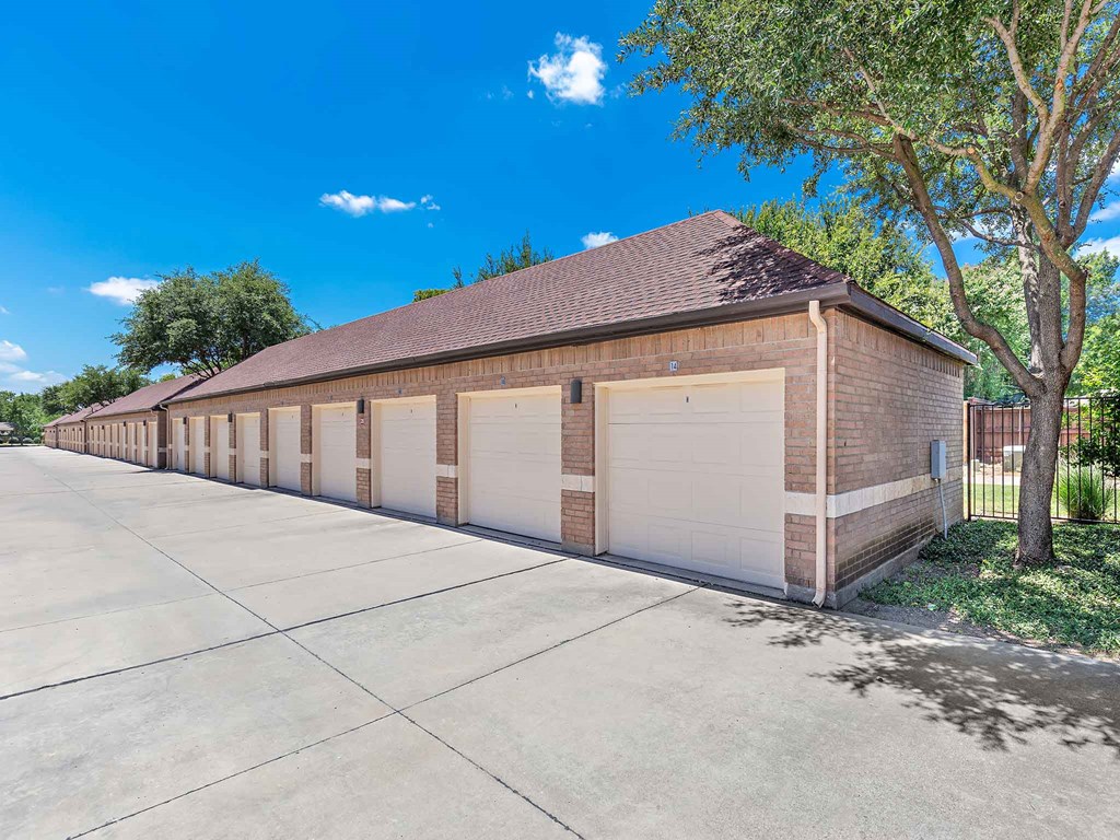 a long row of garages in front of a brick building