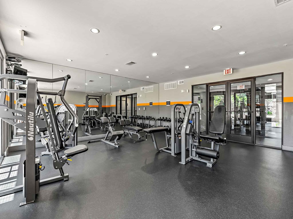 a gym with cardio equipment and glass doors