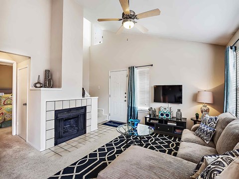 a living room with a ceiling fan and a fireplace
