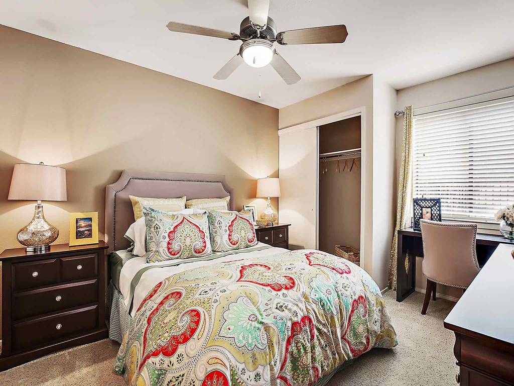 a bedroom with a bed and a ceiling fan