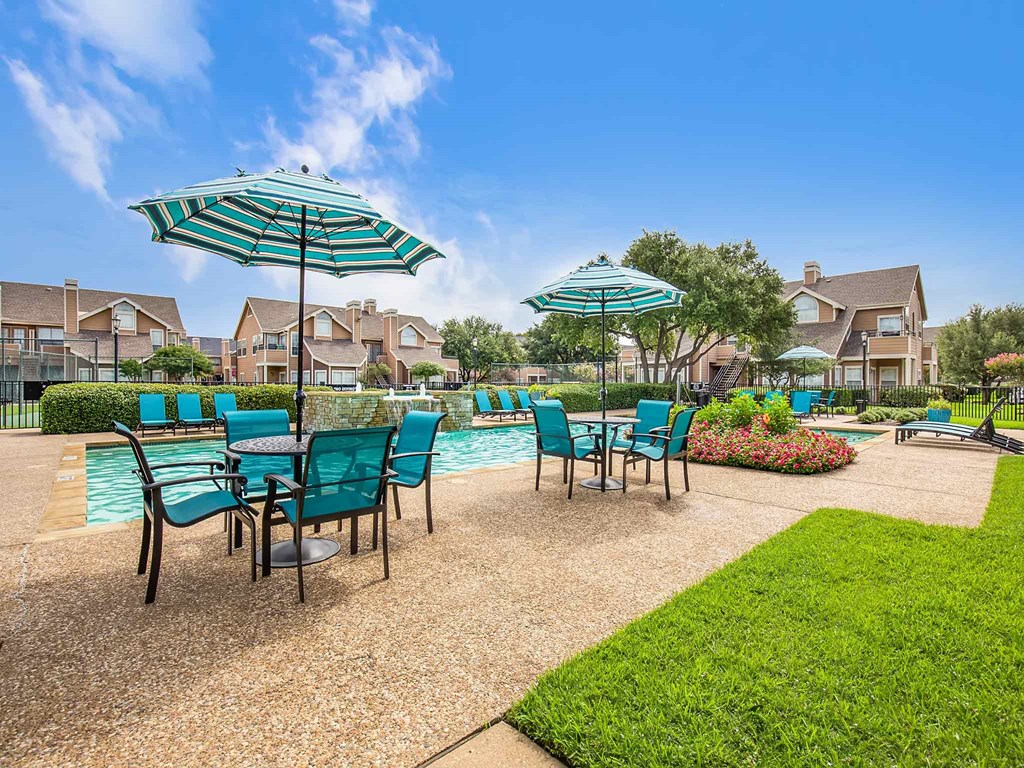 our apartments have a pool and patio with chairs and umbrellas
