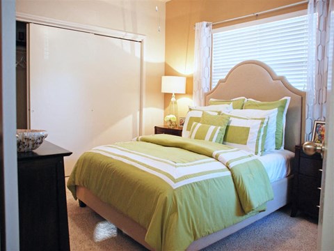 a bedroom with a bed and a dresser and a window