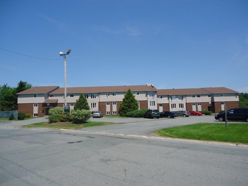 A large building with a parking lot in front.