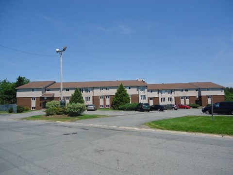 A large building with a parking lot in front.