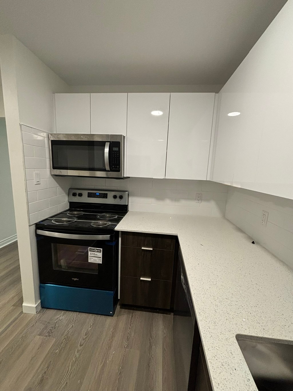 A kitchen with a black stove top oven and a black microwave above it.