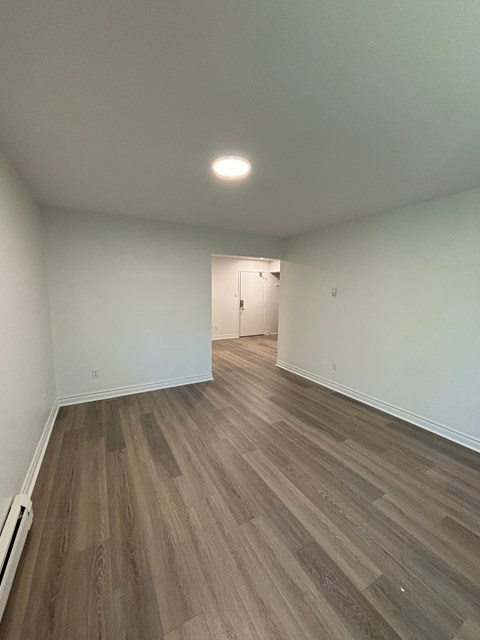 A room with a wooden floor and a white wall.