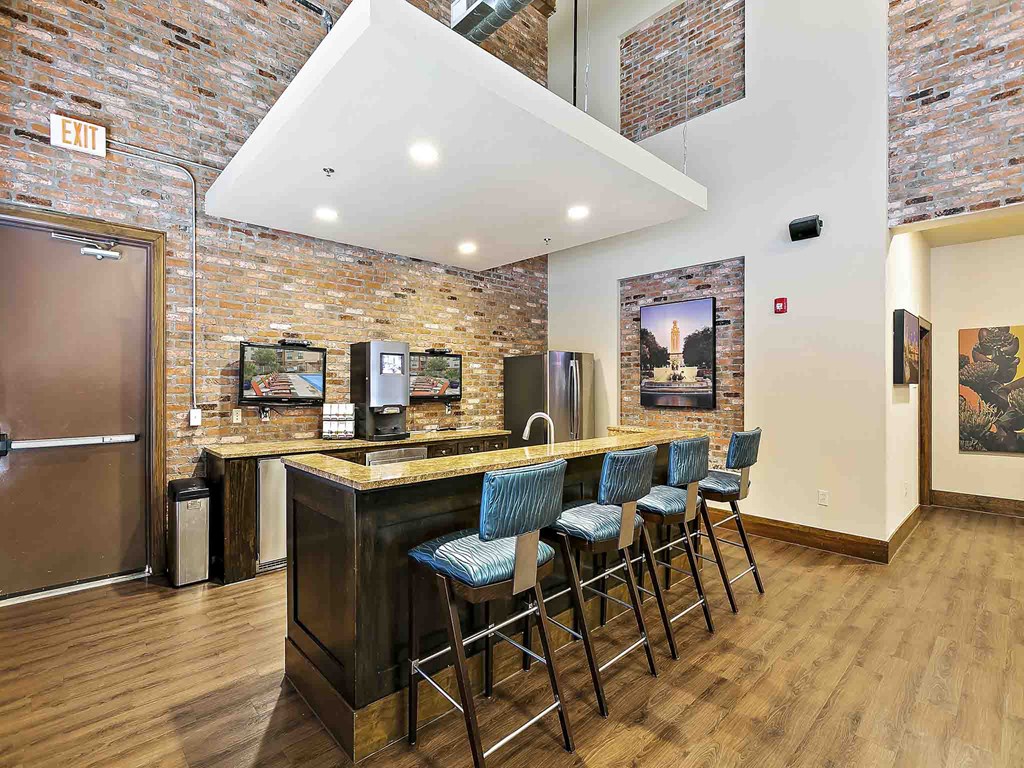 a lobby with a bar with chairs and a refrigerator
