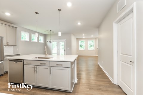 A kitchen with white cabinets and a FirstKey Homes logo.