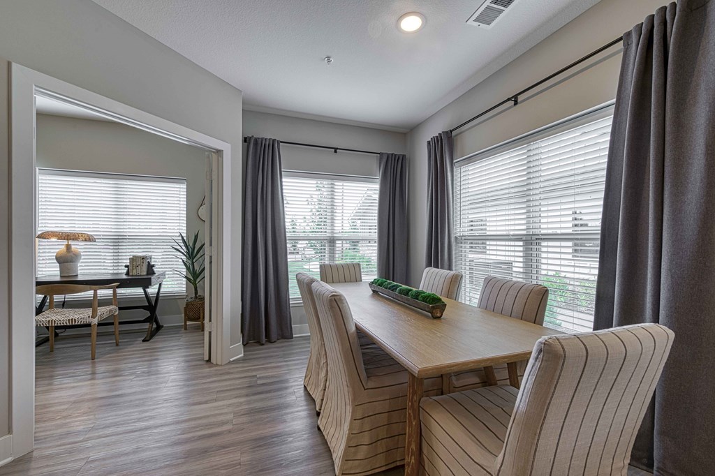 A dining room with a wooden table and striped chairs.