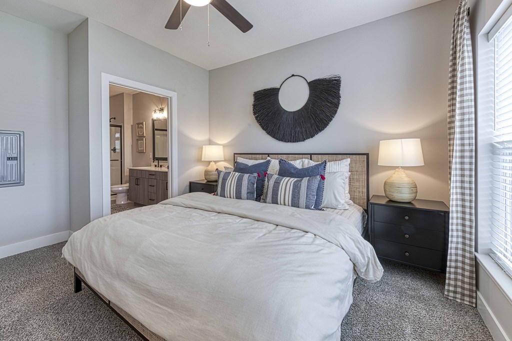 A bedroom with a large bed and a ceiling fan.