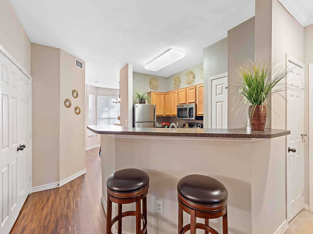 a kitchen with two stools in front of a counter top