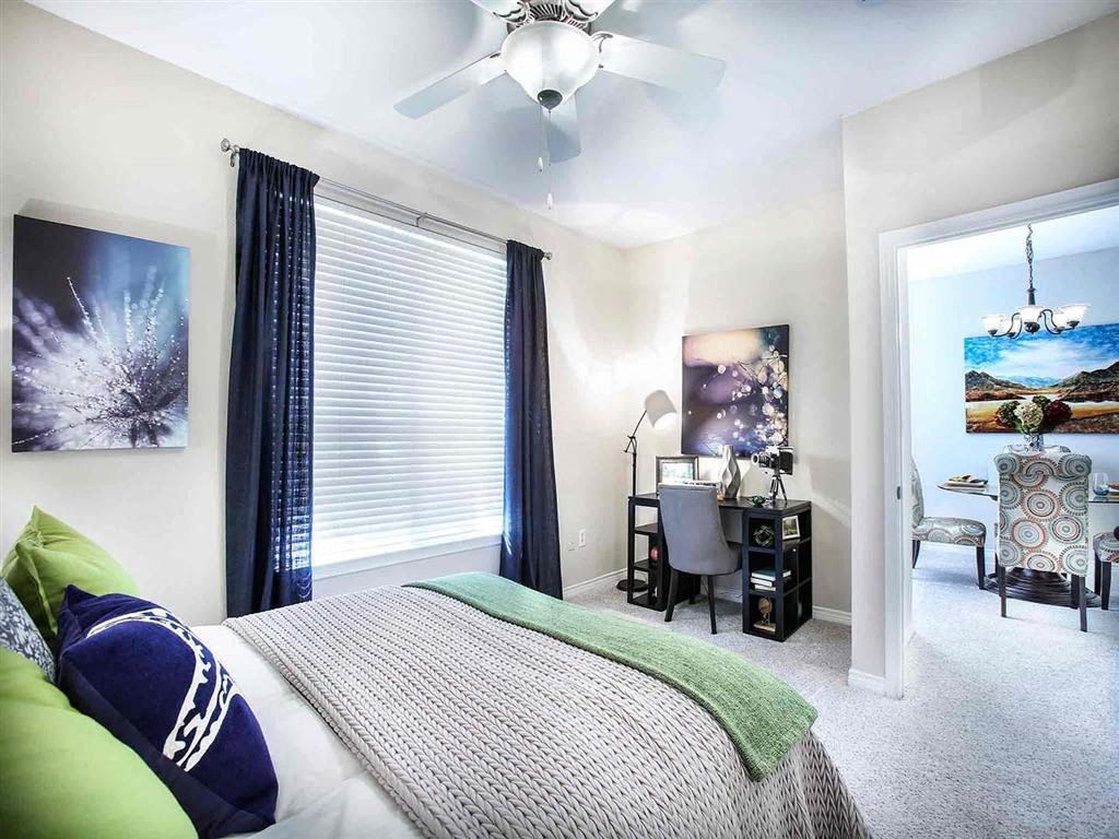 a bedroom with a bed and a ceiling fan