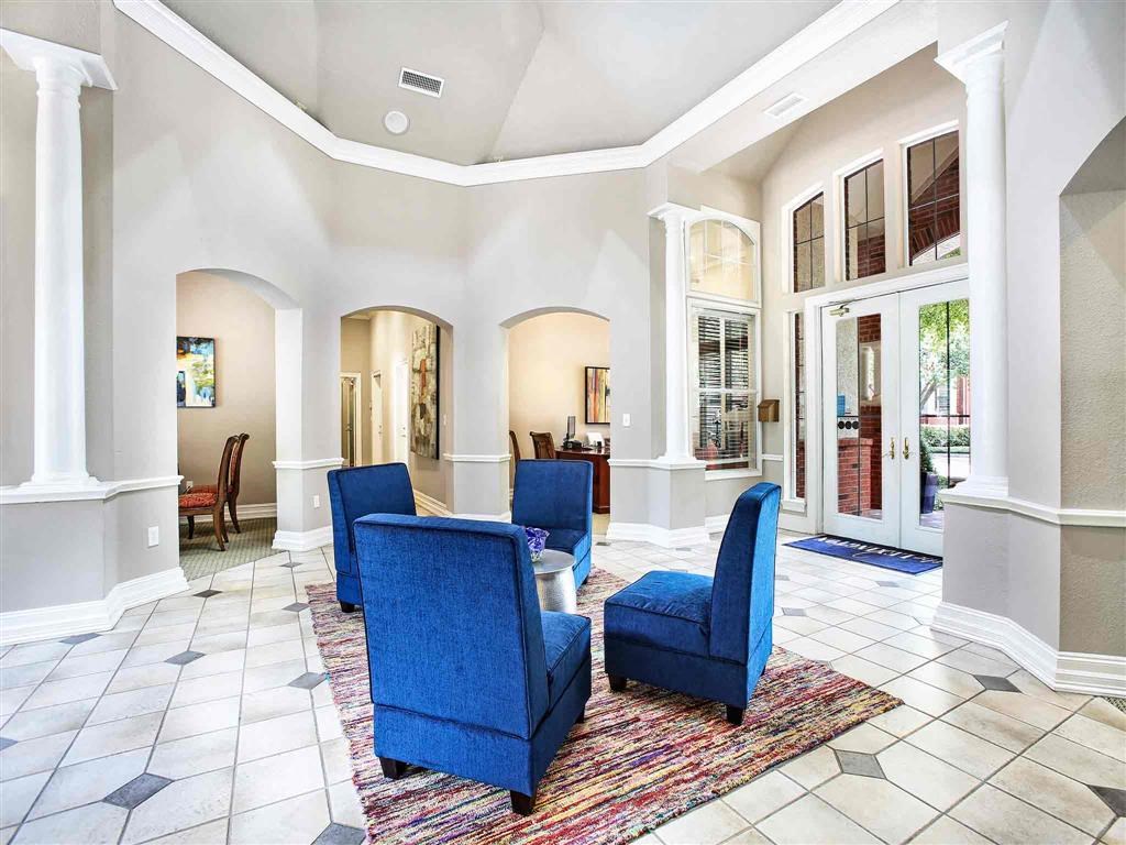 a living room with blue chairs and a rug
