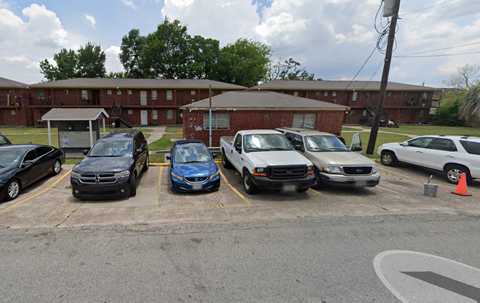 A parking lot with cars and a building in the background.
