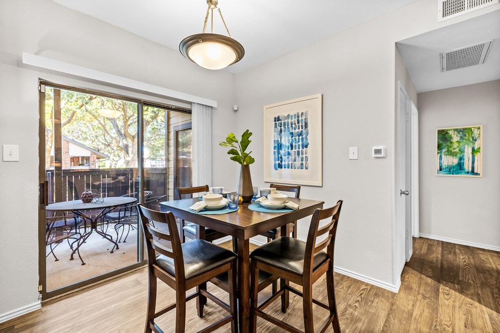 a dining room with a table and chairs and a sliding glass door