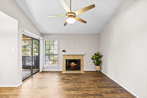 a living room with a fireplace and a ceiling fan